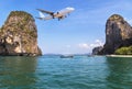 Passenger airplane landing above small island in blue sea and tropical beach Royalty Free Stock Photo