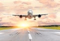 Passenger airplane landing at sunset on a runway. Royalty Free Stock Photo