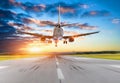 Passenger airplane landing at sunset on a runway. Royalty Free Stock Photo