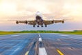 Passenger airplane landing at sunset on a runway. Royalty Free Stock Photo