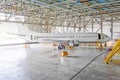 Passenger airplane on maintenance of engine, check repair in airport hangar. Aircraft side view, open hangar doors. Royalty Free Stock Photo