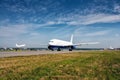 The passenger airplane moves on the main taxiway and behind plane takes off Royalty Free Stock Photo