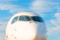 Passenger airplane nose cockpit in blue clouds evening sky Royalty Free Stock Photo