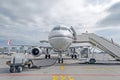 Passenger airplane in the parking at the airport with a nose forward and a gangway. Royalty Free Stock Photo