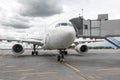 Passenger airplane in the parking at the airport with a nose forward and a gangway Royalty Free Stock Photo