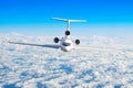 Passenger airplane with three engines on the tail flying at flight level high in the sky above the clouds and blue sky. View direc Royalty Free Stock Photo