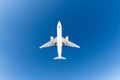 Passenger airplane. View exactly from below, white silhouette against the blue sky. Royalty Free Stock Photo