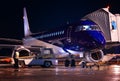 Passenger blue-body plane at night airport. Preflight aircraft service before departure. Loading meal and luggage on