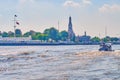 Passenger boat on Chao Phraya river and Wat Arun temple on background, Bangkok, Thailand