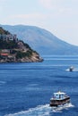 Passenger boats on sea near cliff