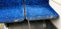 Passenger bus blue seats are soiled with mud because somebody puts his muddy feet on it. Bad behavior example in public area