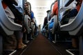 Passenger cabin in flight with people. Economy class. View from floor