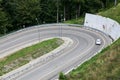 Passenger car pivoting movement at asphalt mountain hairpin road, aerial view