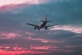 Passenger or cargo plane flies against the background of a red s Royalty Free Stock Photo