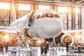 Passenger commercial airplane on maintenance of engine turbo jet and fuselage repair in airport hangar. Aircraft with open hood on Royalty Free Stock Photo
