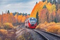 Passenger diesel local train moves at autumn sunset time. Karelia. Royalty Free Stock Photo