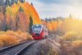 Passenger diesel local train moves at autumn sunset time. Karelia. Royalty Free Stock Photo
