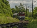 Passenger diesel red big train near Kysak station in summer hot morning