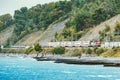 Passenger double deck train moves along the Black sea beach. Sochi