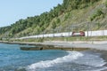 Passenger double deck train moves along the Black sea beach. Sochi