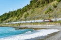 Passenger double deck train moves along Black sea coast. Sochi. Royalty Free Stock Photo