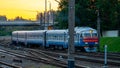 A passenger electric train passes by the railway during sunset. A major railway interchange on the territory of the station. A Royalty Free Stock Photo