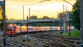 A passenger electric train passes by the railway during sunset. A major railway interchange on the territory of the station. A Royalty Free Stock Photo