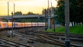 A passenger electric train passes by the railway during sunset. A major railway interchange on the territory of the station. A Royalty Free Stock Photo