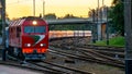 A passenger electric train passes by the railway during sunset. A major railway interchange on the territory of the station. A Royalty Free Stock Photo