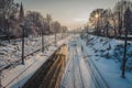 Passenger electric train on the railway at winter sunset behind trees. Royalty Free Stock Photo