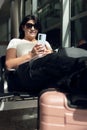 Passenger female traveler at airport waiting for air travel using smart phone Royalty Free Stock Photo
