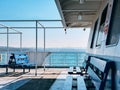 Passenger ferry deck area with blue benches and panoramic sea view Royalty Free Stock Photo