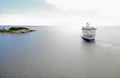 Passenger ferry on the sea in traffic beteen Aland and Grisslehamn, islet with trees and horizon
