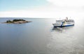 Passenger ferry on the sea in traffic beteen Aland and Grisslehamn, islet with trees and horizon