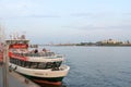 Passenger ferry sightseeing tour boat at St. Pauli`s Piers or LandungsbrÃÂ¼cken with shipyards and clouds in blue sky background. Royalty Free Stock Photo