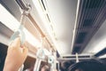 Passenger hand holding onto a handle of a train on blur background, Woman holding onto a handle on a train