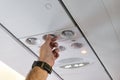 Passenger hand turning adjust temperature of air conditioner on cabin in airplane