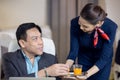 Passenger have orange juice served by an air hostess in airplane, Flight attendants serve on board Royalty Free Stock Photo