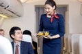 Passenger have orange juice served by an air hostess in airplane, Flight attendants serve on board Royalty Free Stock Photo