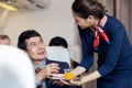 Passenger have orange juice served by an air hostess in airplane, Flight attendants serve on board Royalty Free Stock Photo