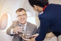 Passenger have water served by an air hostess in airplane, Flight attendants serve on board Royalty Free Stock Photo