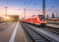 Passenger high speed train on the railway station at sunset Royalty Free Stock Photo