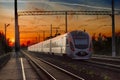 Passenger inter-city train in city on the sunset background Royalty Free Stock Photo