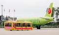 Passenger jet aircraft Airbus A320 of S7 Airlines on airfield. Bus near by jet is ready to get passengers.