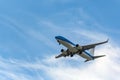 Passenger jet airplane in mid-flight against blue sky with clouds, getting ready for landing. Royalty Free Stock Photo