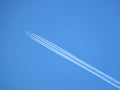 Passenger jet flying in clear blue sky, leaving white trail