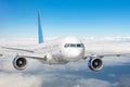 Passenger jet plane in the blue sky. Aircraft flying high through the cumulus clouds. Close up view airplane in flight Royalty Free Stock Photo