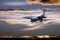 Passenger jet plane flying in the evening sky at sunset Royalty Free Stock Photo