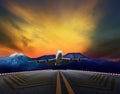 Passenger jet plane flying over airport runways against beautiful dusky sky