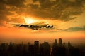 passenger jet plane flying over urban scene against beautiful sun set sky use for air transport and traveling theme Royalty Free Stock Photo